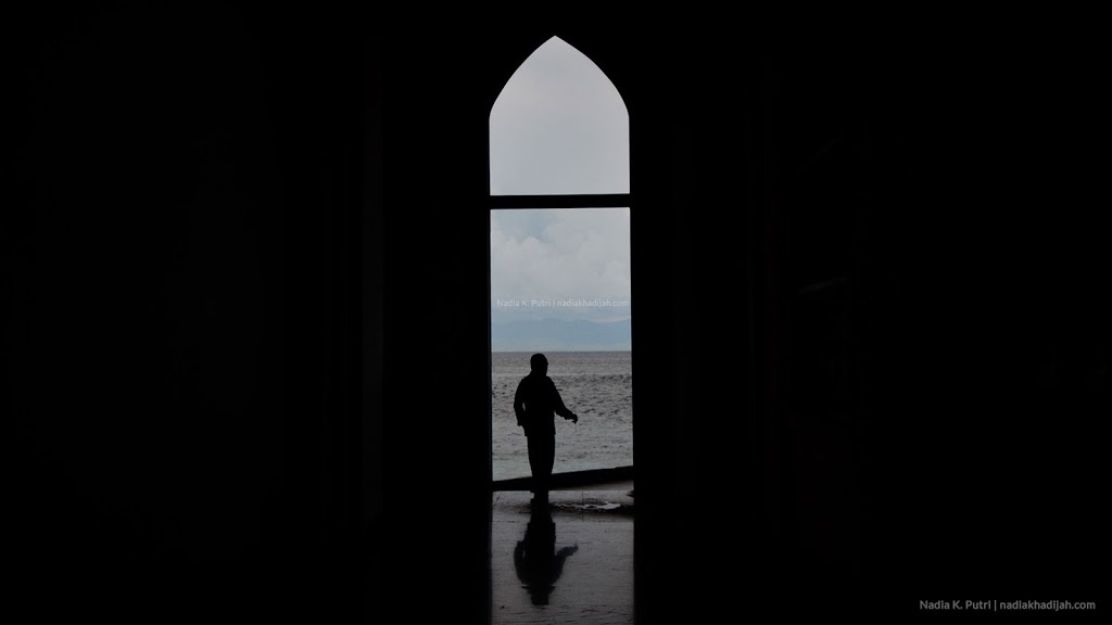 Seorang pria memandangi lautan dari dalam Masjid Al Munawwar, Ternate, Maluku Utara (Foto: Nadia K. Putri/nadiakhadijah.com)